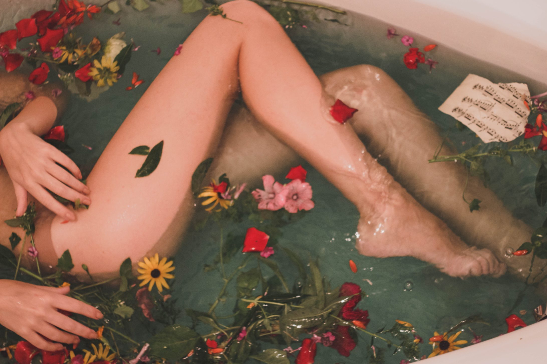 woman in a bath, with flowers and leaves
